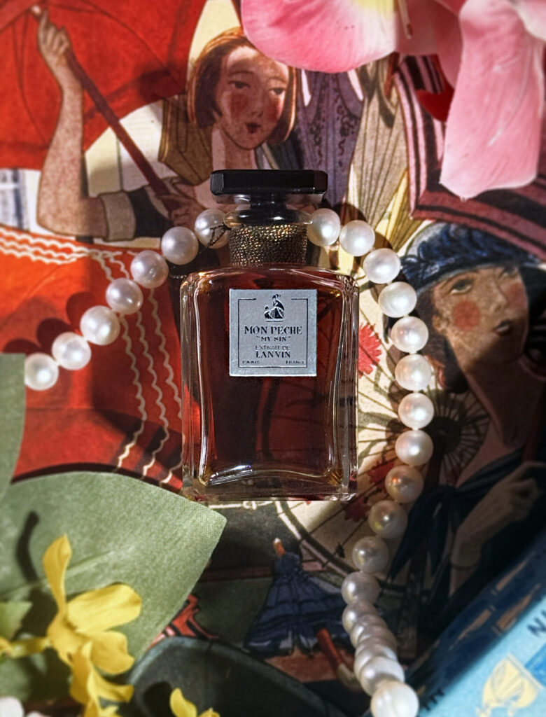 Extrait bottle of Lanvin Mon Peche (My Sin), surrounded by flowers and pearls, over an illustration of women with parasols.